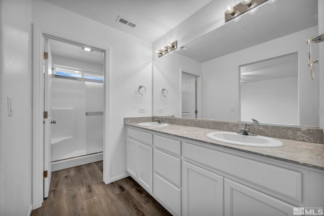 bathroom with hardwood / wood-style floors, vanity, and walk in shower