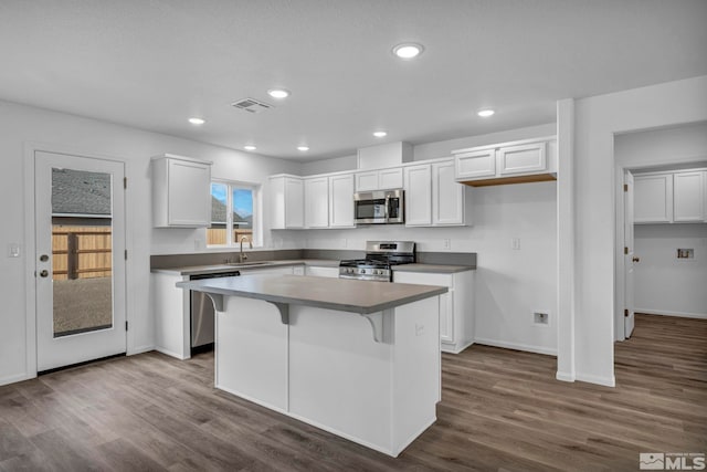 kitchen featuring white cabinets, a kitchen island, sink, and stainless steel appliances