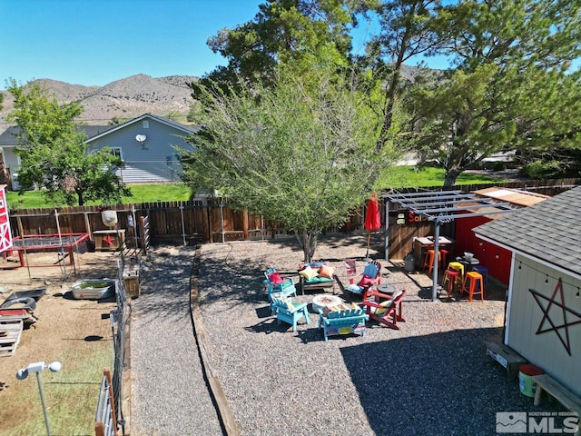 view of yard featuring a mountain view and an outdoor fire pit