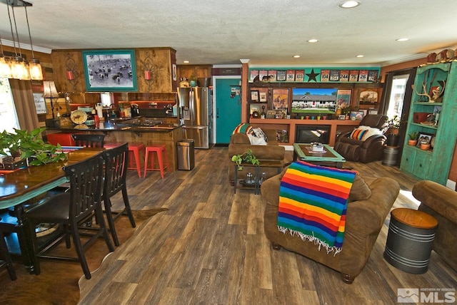 dining room with crown molding, dark wood-type flooring, and a textured ceiling