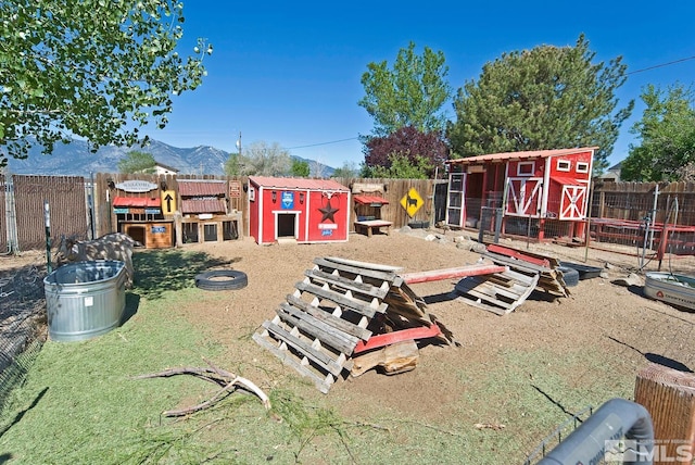 view of play area with an outbuilding and a mountain view