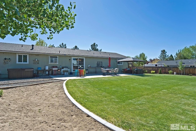 rear view of property featuring a yard and a patio area