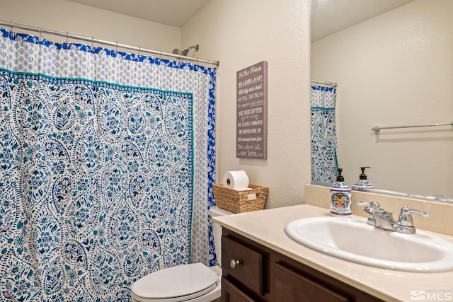 bathroom featuring vanity, curtained shower, and toilet