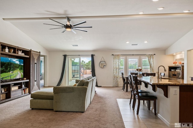 carpeted living room featuring lofted ceiling with beams, ceiling fan, plenty of natural light, and sink