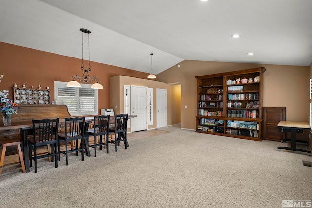 carpeted dining room featuring vaulted ceiling