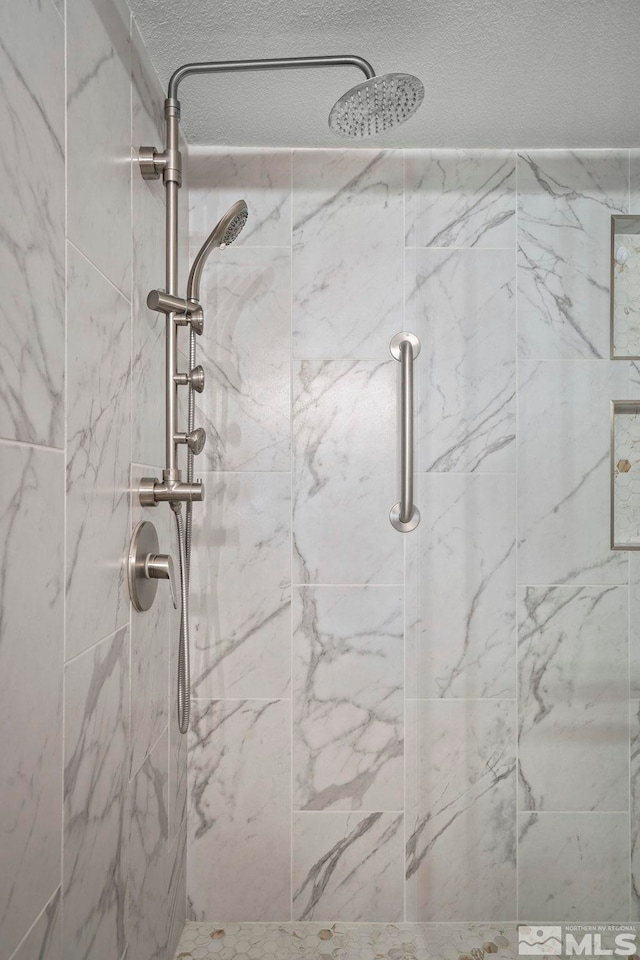 bathroom featuring a tile shower and a textured ceiling