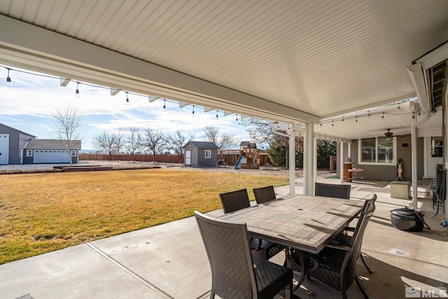 view of patio featuring a storage unit and a playground