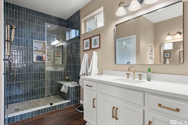 bathroom featuring a tile shower, vanity, and hardwood / wood-style flooring