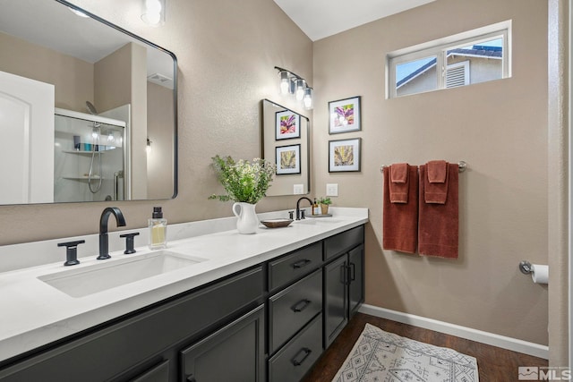 bathroom with hardwood / wood-style floors, vanity, and an enclosed shower