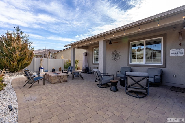 view of patio with ceiling fan and a fire pit