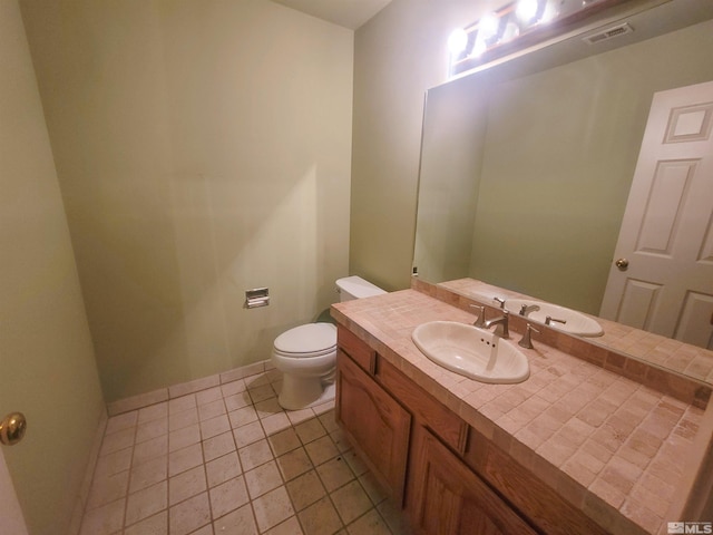 bathroom with tile patterned flooring, vanity, and toilet