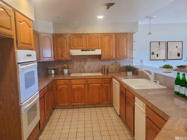 kitchen featuring sink, backsplash, decorative light fixtures, white appliances, and light tile patterned floors