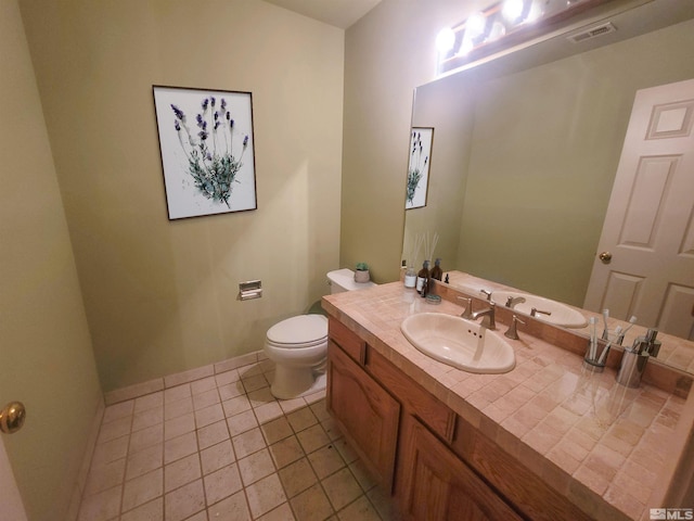 bathroom featuring tile patterned flooring, vanity, and toilet