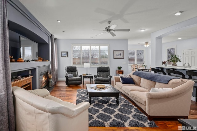 living room with dark hardwood / wood-style flooring and ceiling fan