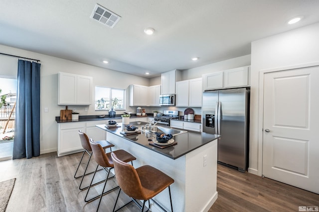 kitchen featuring a breakfast bar, white cabinetry, and appliances with stainless steel finishes