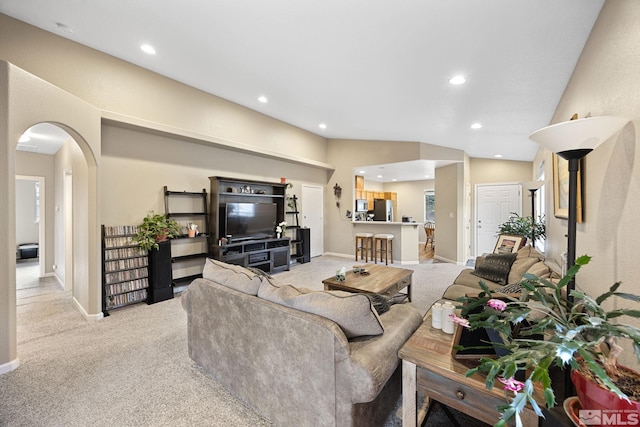 carpeted living room with lofted ceiling