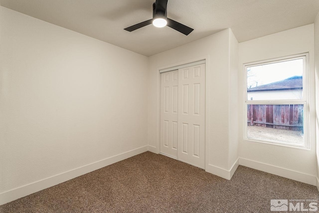 unfurnished bedroom featuring carpet, ceiling fan, and a closet