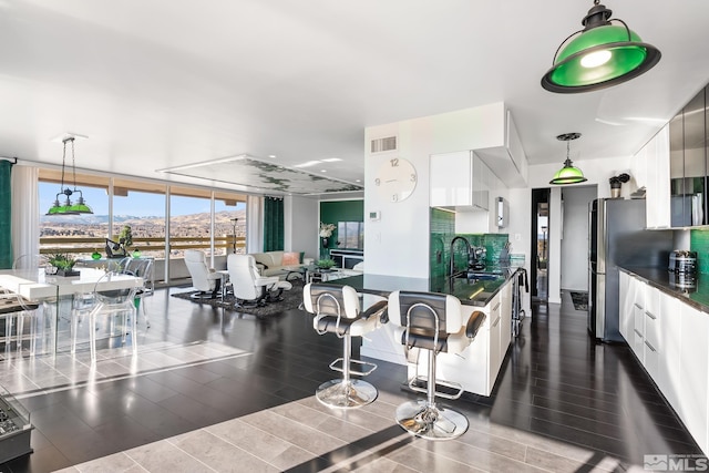 kitchen featuring white cabinets, decorative light fixtures, and floor to ceiling windows