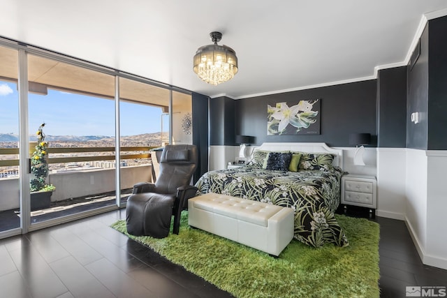 bedroom with an inviting chandelier, expansive windows, a mountain view, crown molding, and access to outside