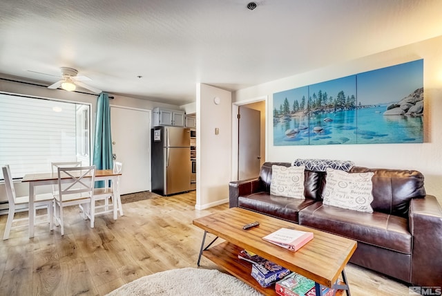 living room featuring ceiling fan and light hardwood / wood-style flooring