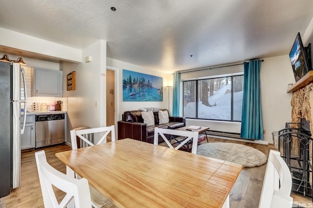 dining room with a textured ceiling and light wood-type flooring