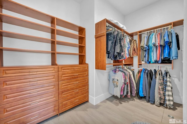 walk in closet with light hardwood / wood-style floors