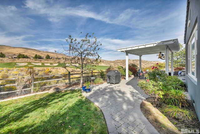 view of yard with a pergola, a mountain view, and a patio