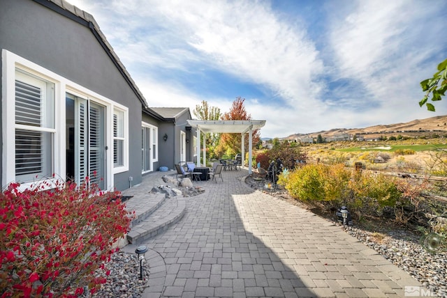 view of patio / terrace with a pergola and a mountain view