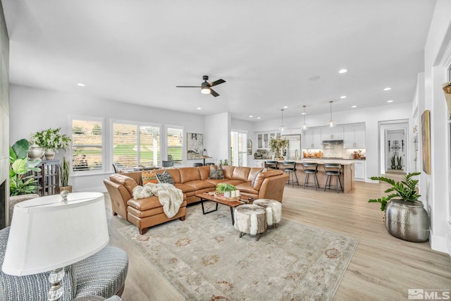 living room featuring light wood-type flooring and ceiling fan