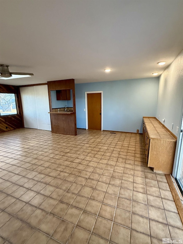 unfurnished living room with ceiling fan