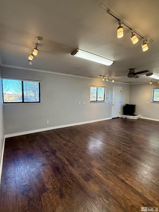 unfurnished room featuring ornamental molding, dark hardwood / wood-style flooring, track lighting, and plenty of natural light