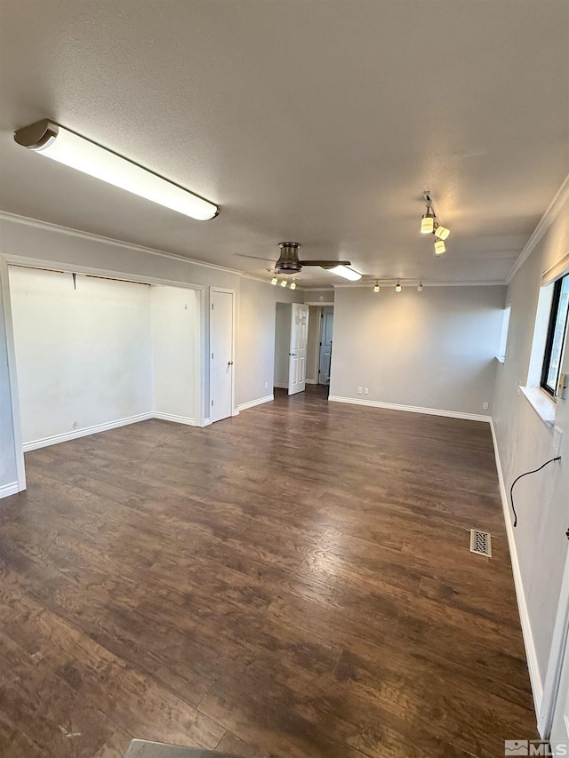 interior space with dark wood-type flooring, a textured ceiling, ceiling fan, and crown molding