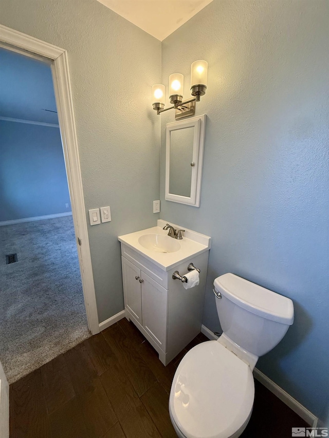 bathroom featuring toilet, wood-type flooring, and vanity