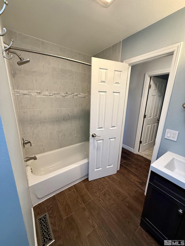 bathroom featuring tiled shower / bath combo, vanity, and hardwood / wood-style floors