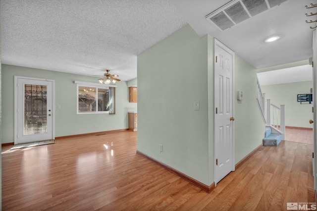 interior space with light wood-type flooring and a textured ceiling