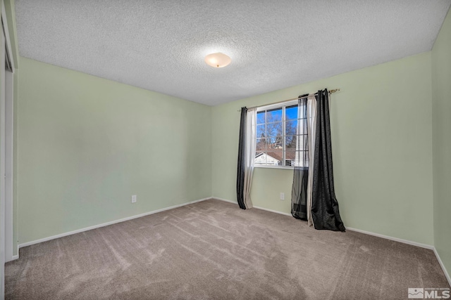 carpeted empty room featuring a textured ceiling