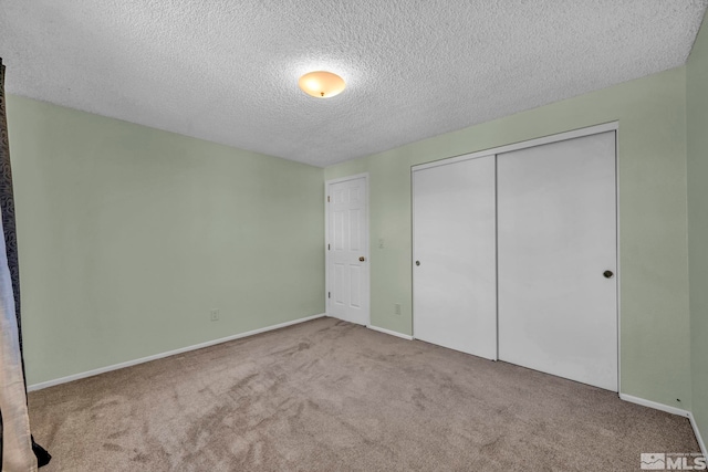 unfurnished bedroom featuring light colored carpet, a textured ceiling, and a closet