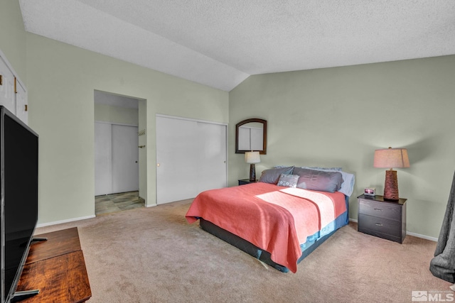 carpeted bedroom with a textured ceiling and lofted ceiling