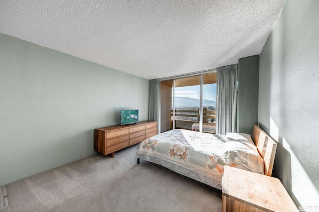 bedroom featuring floor to ceiling windows, a textured ceiling, and carpet floors