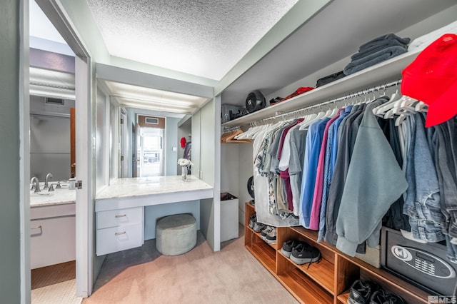 walk in closet featuring light carpet