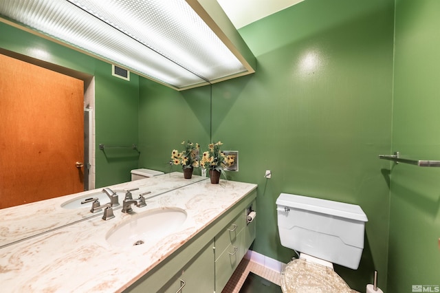 bathroom with toilet, tile patterned flooring, and vanity