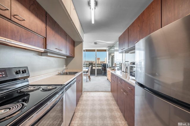 kitchen featuring stainless steel appliances, light carpet, and sink