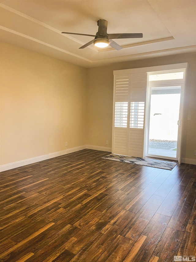 unfurnished room with ceiling fan, dark hardwood / wood-style flooring, and a raised ceiling