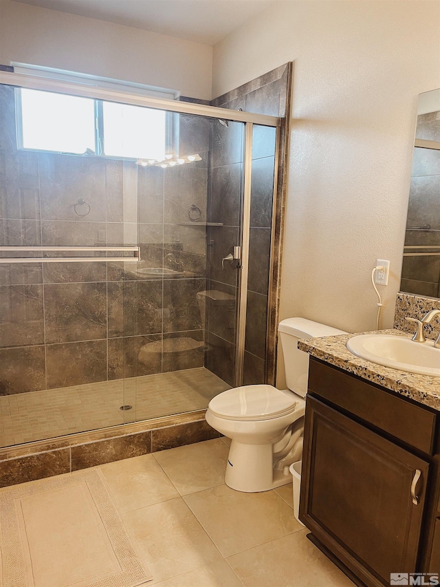 bathroom featuring vanity, tile patterned flooring, a shower with shower door, and toilet