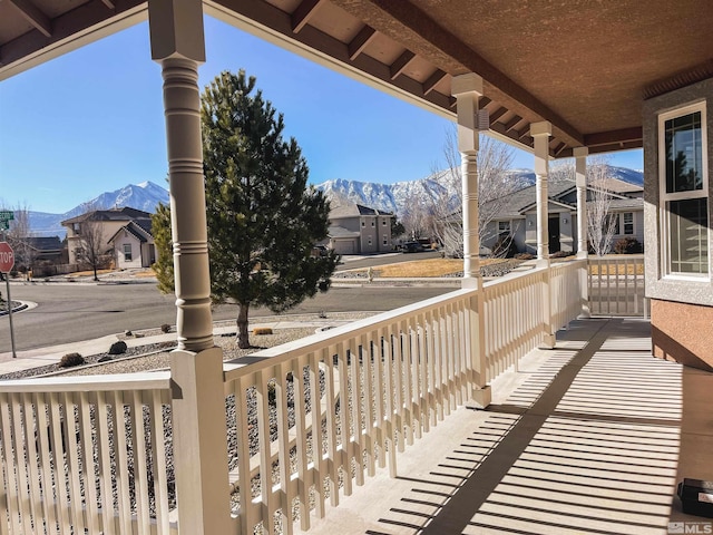 deck with covered porch and a mountain view