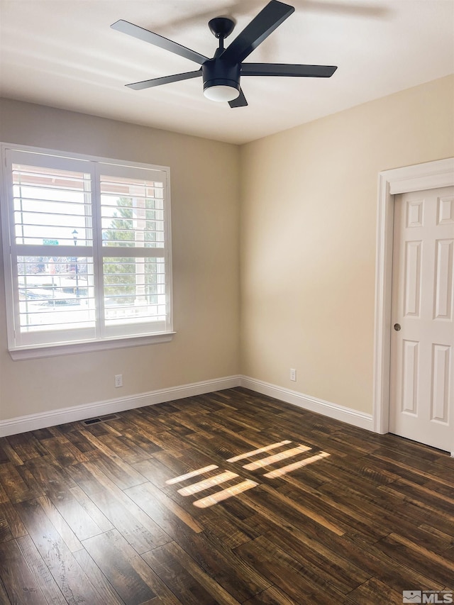 unfurnished room with ceiling fan and dark hardwood / wood-style flooring