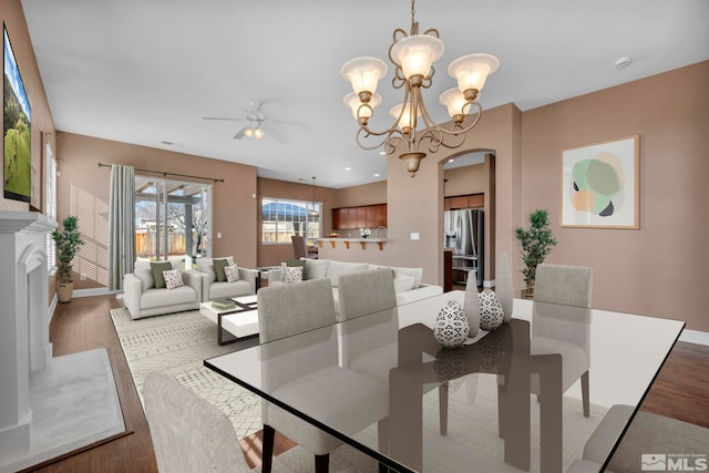 dining area featuring light wood-type flooring and ceiling fan with notable chandelier