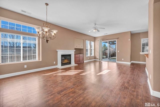 unfurnished living room featuring dark hardwood / wood-style flooring and ceiling fan with notable chandelier