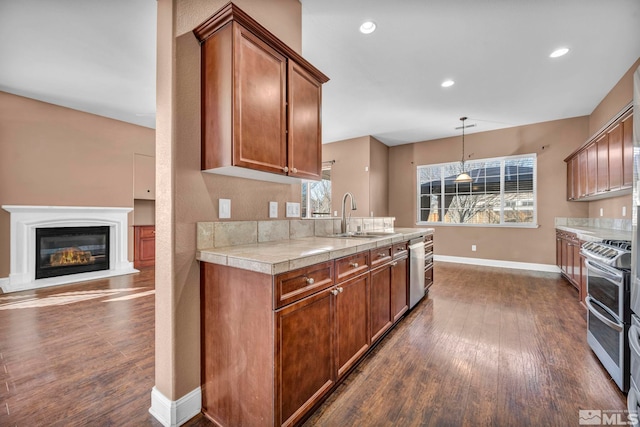 kitchen featuring dark hardwood / wood-style flooring, stainless steel appliances, hanging light fixtures, and sink