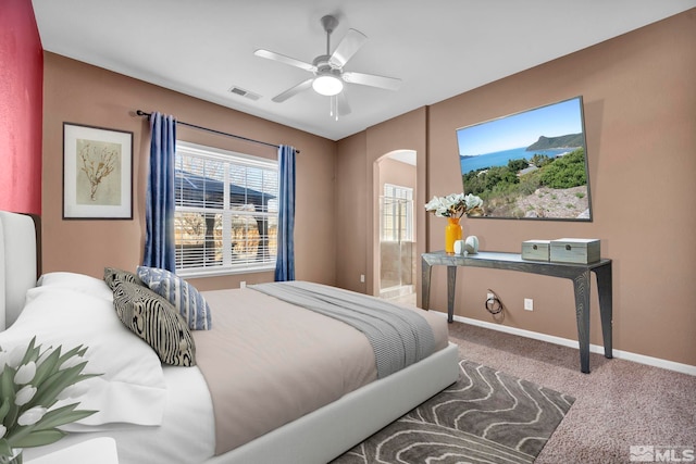 bedroom with ceiling fan, ensuite bath, and carpet